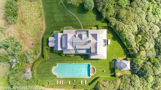 an aerial view of a house with garden space and a swimming pool