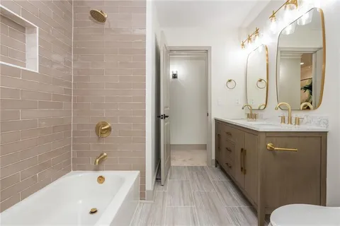 a bathroom with a tub a sink and mirror