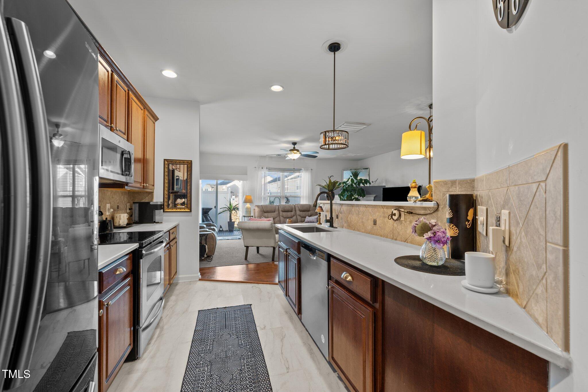 4027 Comrie Lane Burlington, NC 27215 - Photo 16 of 47 a kitchen with stainless steel appliances a sink stove and refrigerator