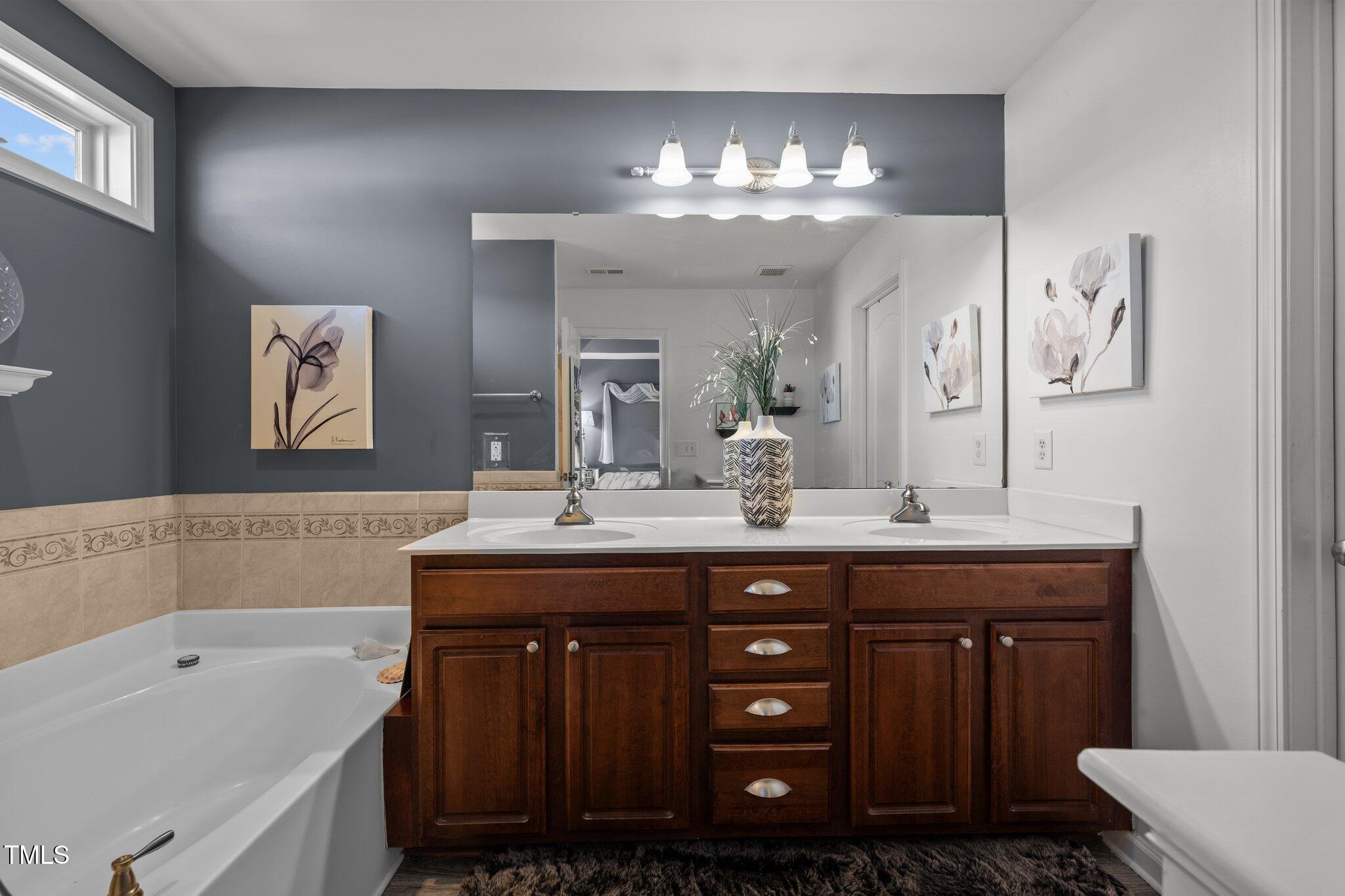 4027 Comrie Lane Burlington, NC 27215 - Photo 25 of 47 a spacious bathroom with a sink double vanity granite and a mirror