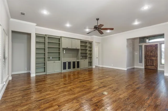 wooden floor in an empty room with a kitchen
