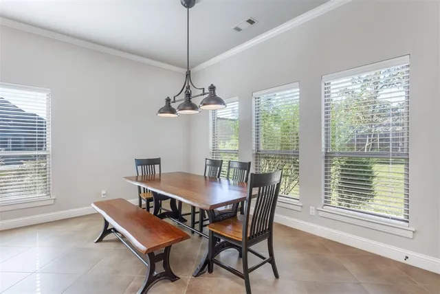 a dining room with furniture a chandelier and wooden floor