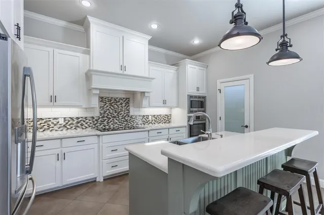 a kitchen with sink cabinets and chairs