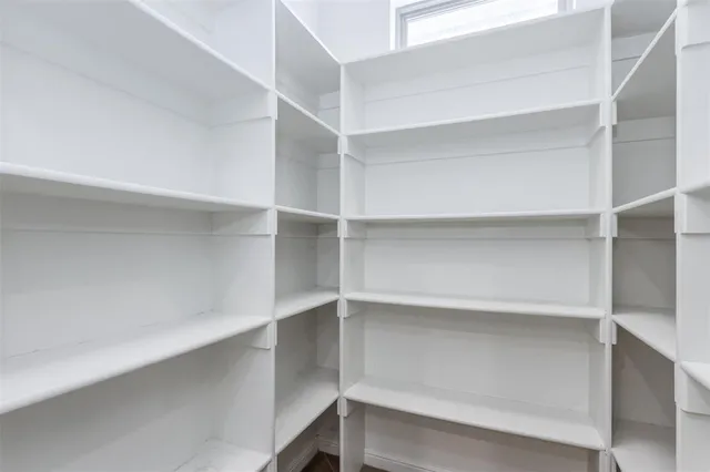 a view of walk in closet with empty racks