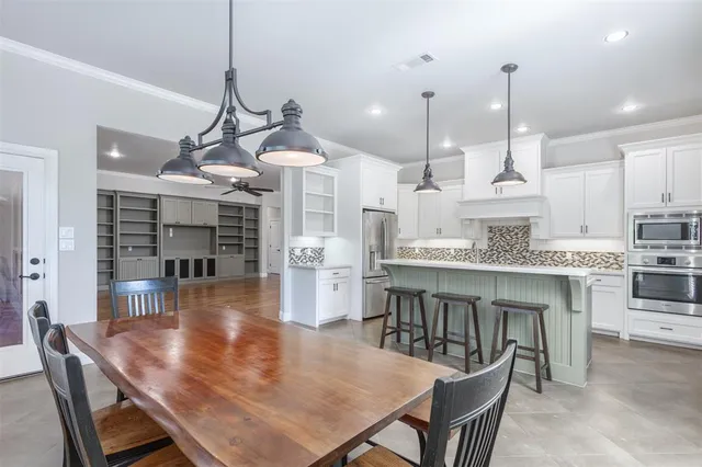 a large kitchen with a table and chairs