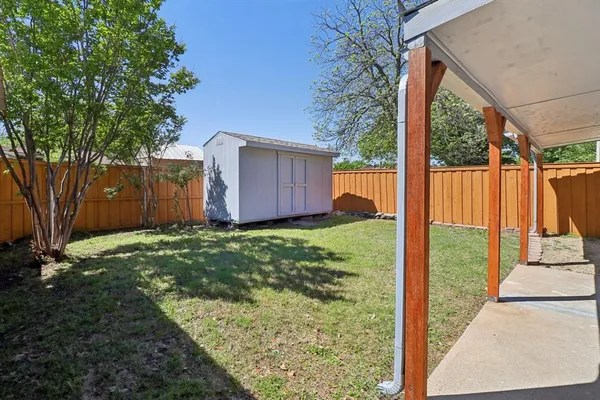a view of a chair and table in backyard of the house