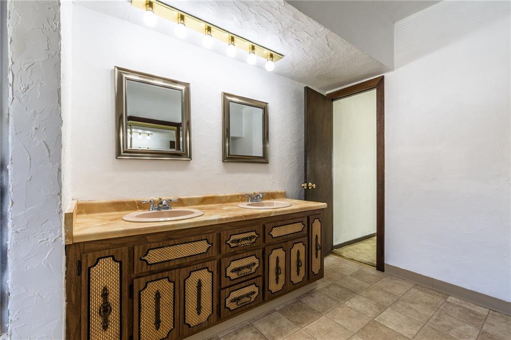 3260 Millers Run Road Cecil, PA 15321 - Photo 13 of 22 a bathroom with a sink a mirror and a painting on the wall