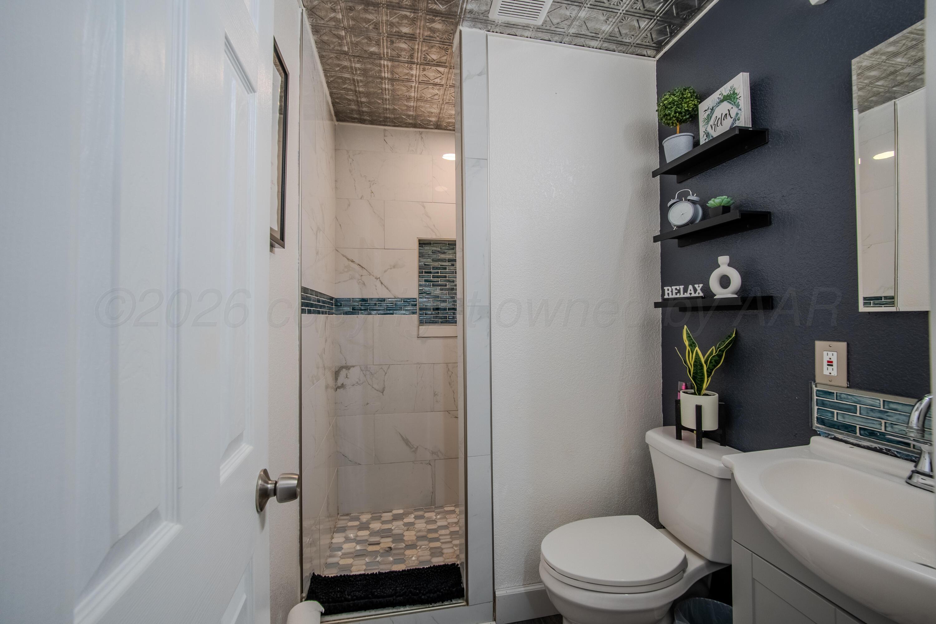 4014 Gables Street Amarillo, TX 79110 - Photo 9 of 14 a bathroom with a toilet and a shower