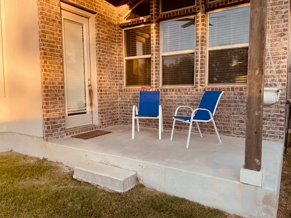 a view of a patio with table and chairs and potted plants