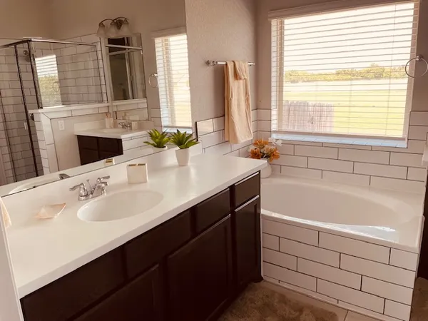 a bathroom with a bathtub sink and a mirror