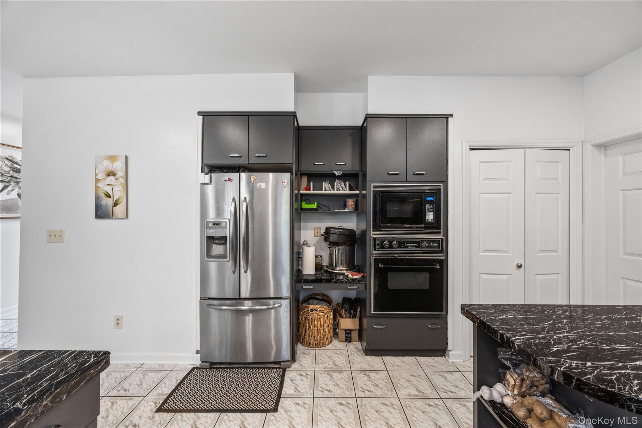 3 Miller Road Putnam Valley, NY 10579 - Photo 12 of 48 Stainless steel French door refrigerator, black wall oven, and built-in microwave complement the dark cabinetry