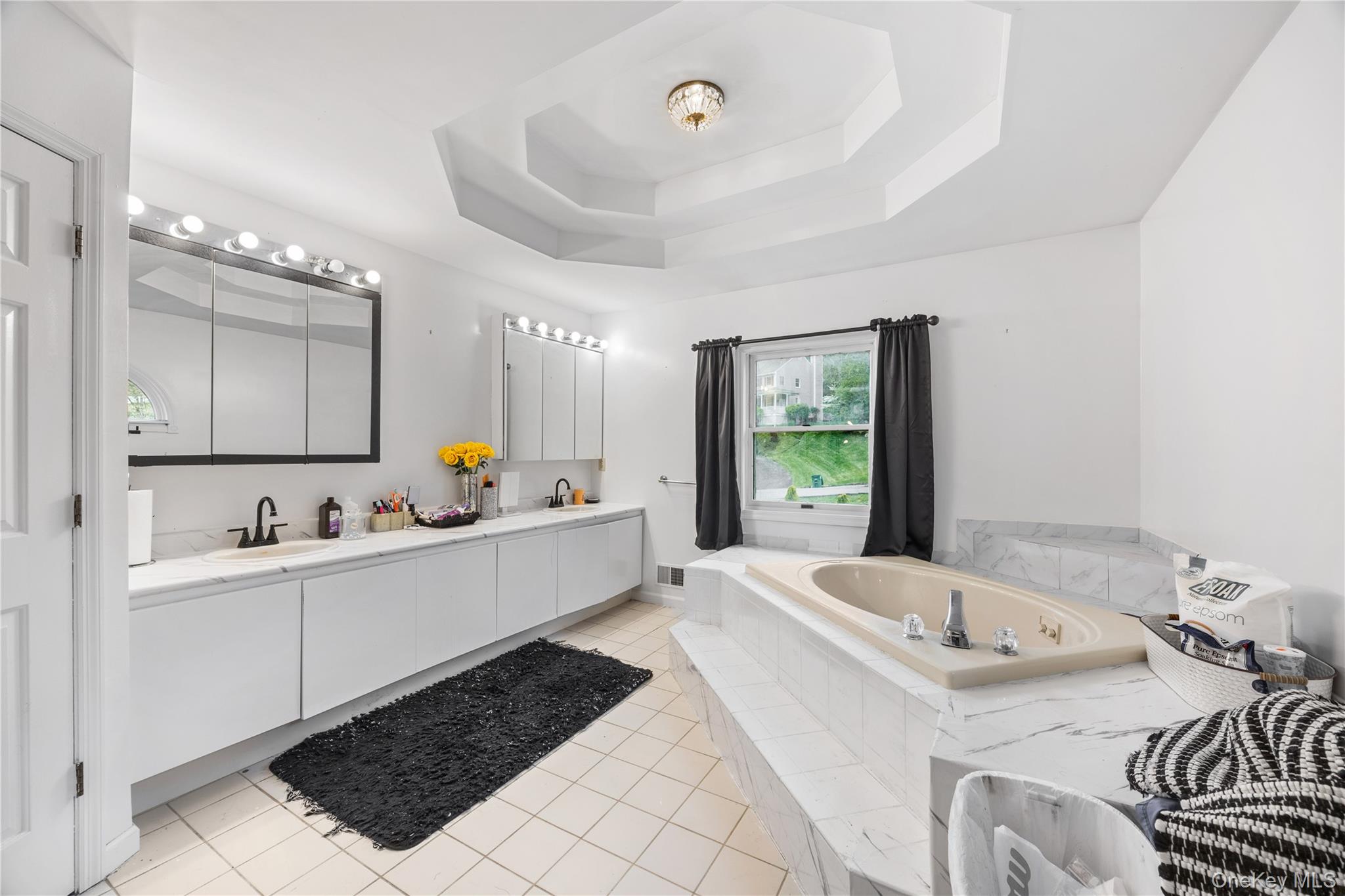 3 Miller Road Putnam Valley, NY 10579 - Photo 32 of 48 Recessed tub with tiled surround, dual vanity with undermount sinks, and a tray ceiling
