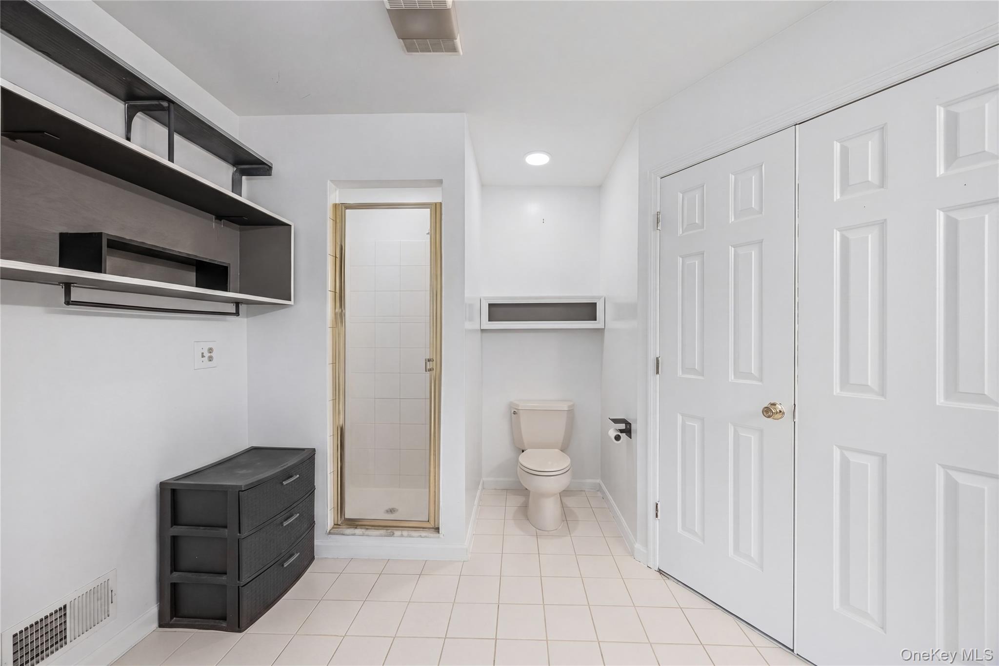 3 Miller Road Putnam Valley, NY 10579 - Photo 36 of 48 Bathroom featuring a tile-surround shower with glass door, white tile flooring, and a white toilet