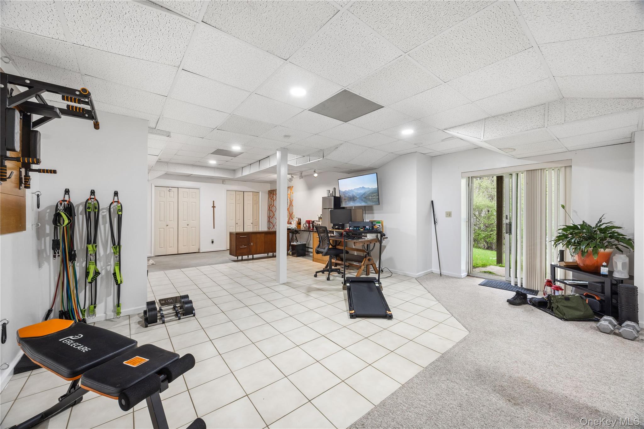 3 Miller Road Putnam Valley, NY 10579 - Photo 39 of 48 Lower level featuring a sliding glass door for outdoor access, mixed flooring with tile and carpeted areas, recessed lighting, and multiple bi-fold closet doors