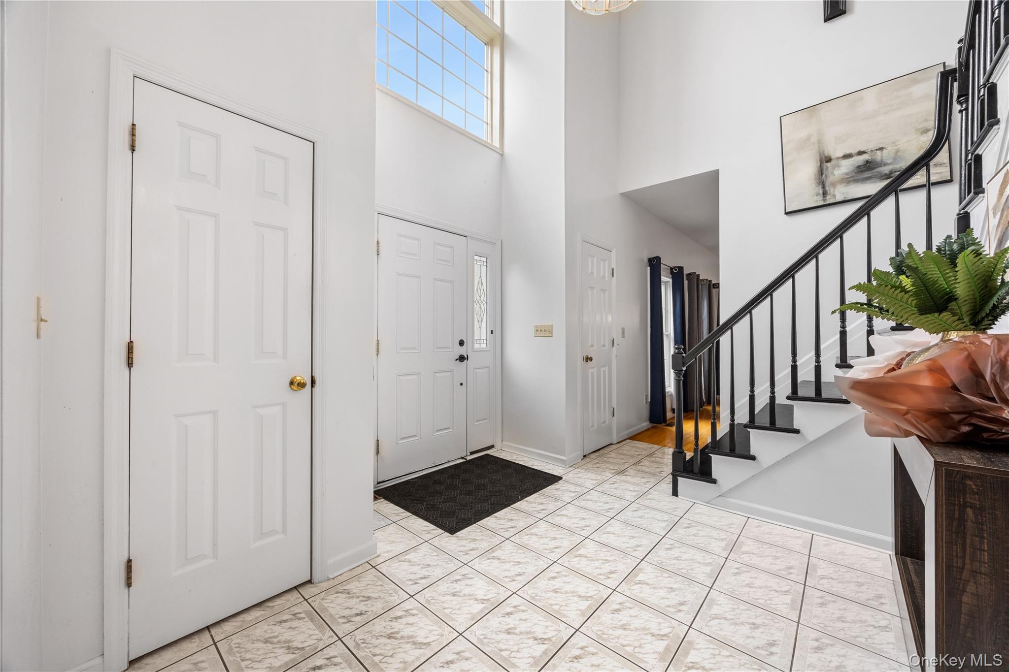3 Miller Road Putnam Valley, NY 10579 - Photo 4 of 48 Two-story foyer with ceramic tile flooring, a prominent staircase with black banister and treads, and a high window feature