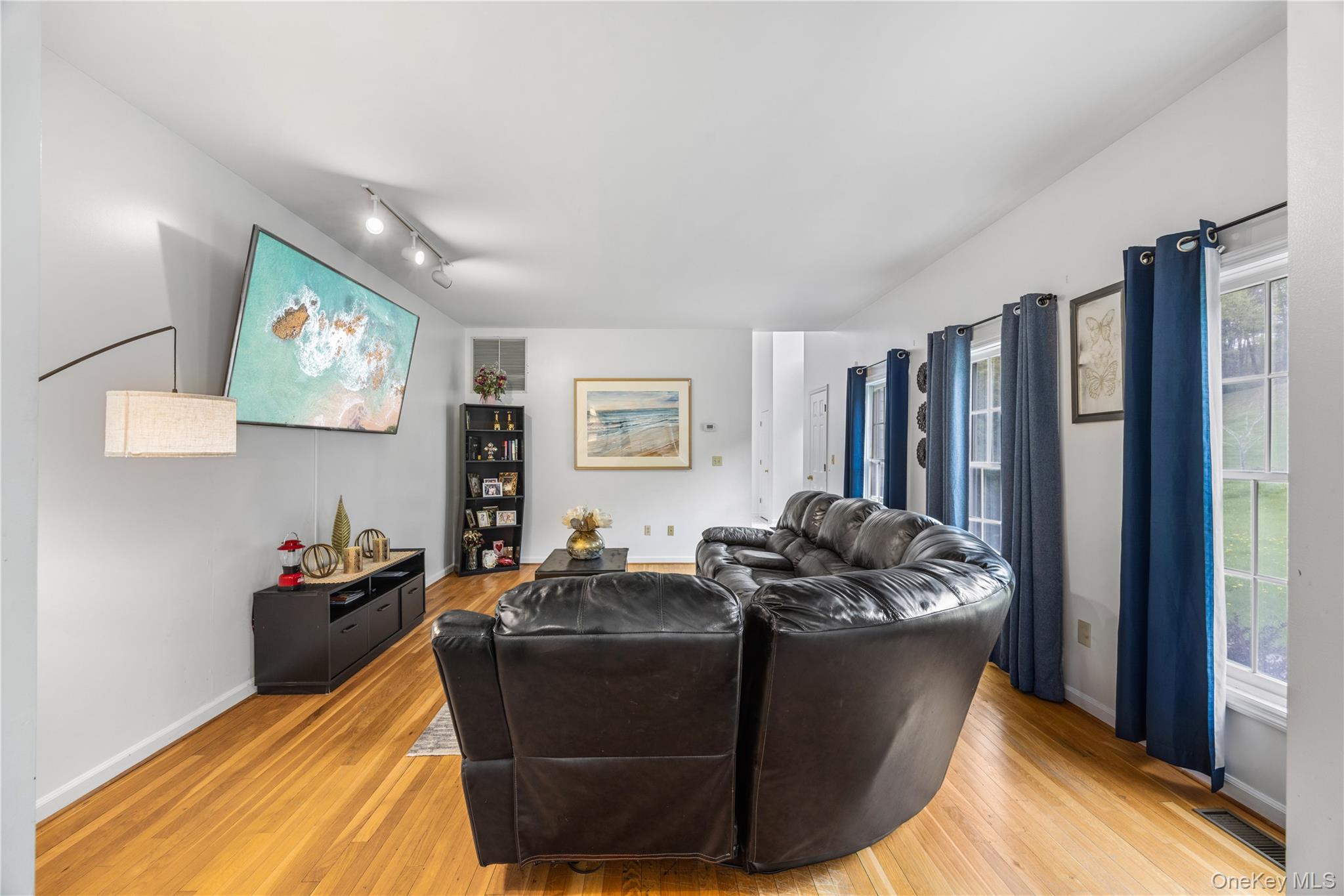 3 Miller Road Putnam Valley, NY 10579 - Photo 6 of 48 Spacious living area featuring vaulted ceilings, track lighting, wood-finish flooring, and multiple windows providing natural light