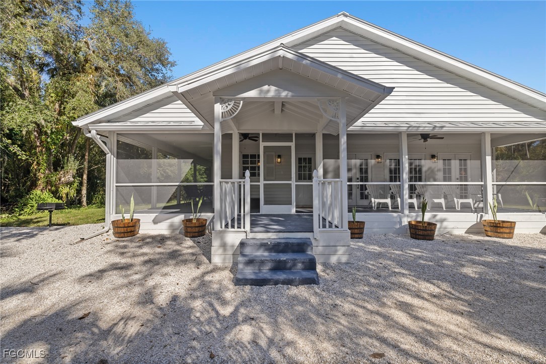 17780-800 Caloosa Road Alva, FL 33920 - Photo 3 of 42 a view of a house with a large window and wooden fence