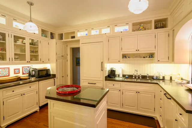 a kitchen with kitchen island granite countertop a sink a stove and cabinets