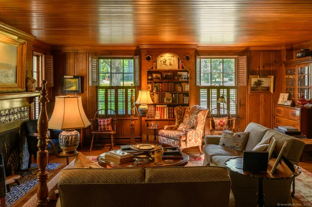 a living room with furniture a flat screen tv and floor to ceiling window