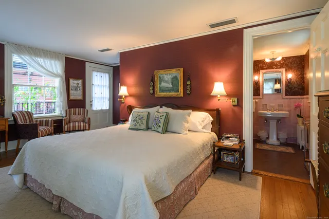 a bedroom with a bed and large mirror with window