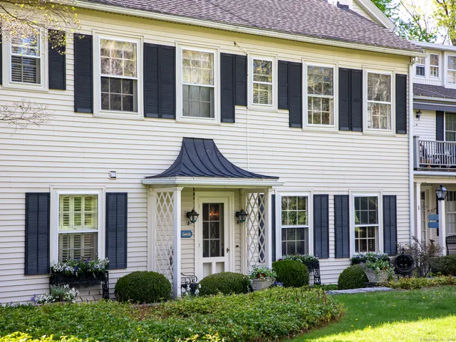a view of a brick house with yard and large windows