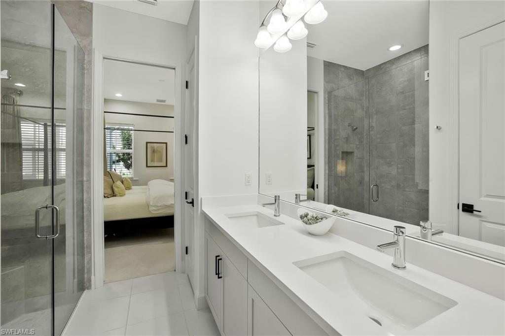 7295 Cayo Coco Lane Naples, FL 34113 - Photo 13 of 16 a en suite bathroom with a double sink and mirror