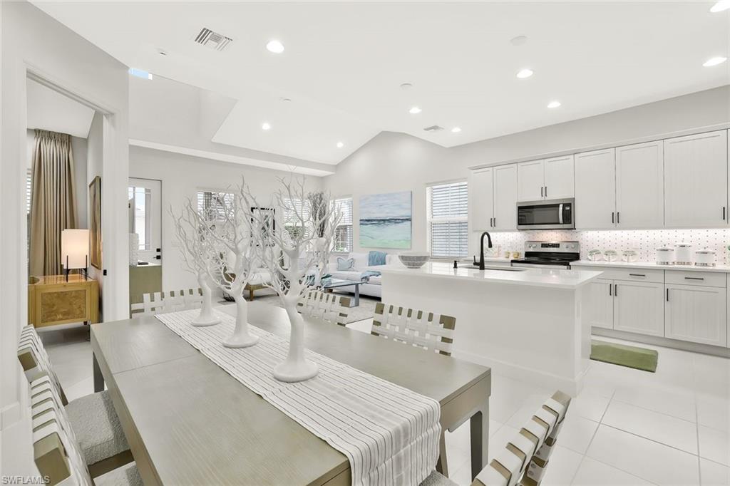 7295 Cayo Coco Lane Naples, FL 34113 - Photo 10 of 16 a kitchen with stainless steel appliances kitchen island granite countertop a sink and cabinets