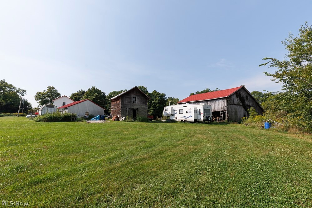 5366 Zenobia Road Wakeman, OH 44889 - Photo 23 of 25 Expansive green space featuring multiple outbuildings, including a large barn with a red roof