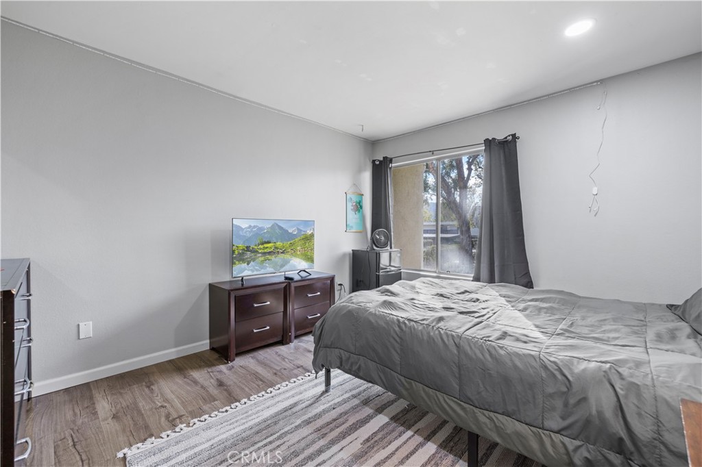 23515 Lyons Avenue, Unit 277 Valencia, CA 91355 - Photo 11 of 29 a bedroom with a bed and wooden floor