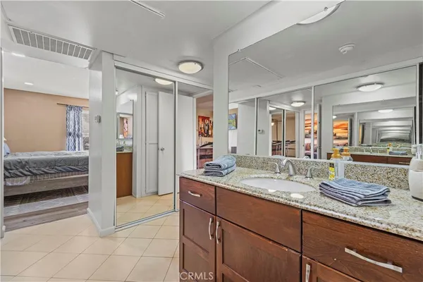 a en suite bathroom with a granite countertop sink mirror and double