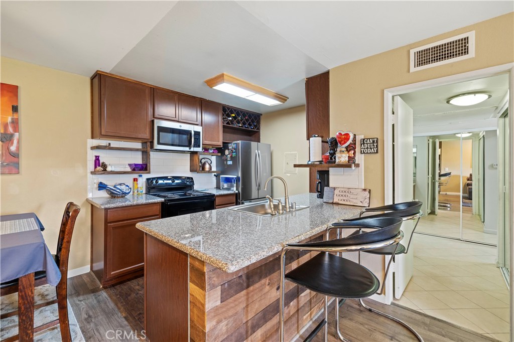 23515 Lyons Avenue, Unit 277 Valencia, CA 91355 - Photo 6 of 29 a kitchen with a table and chairs in it