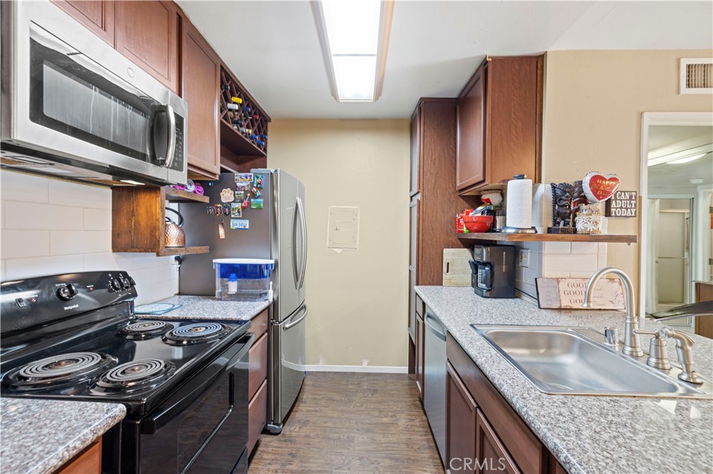 23515 Lyons Avenue, Unit 277 Valencia, CA 91355 - Photo 8 of 29 a kitchen with stainless steel appliances granite countertop a sink stove and refrigerator