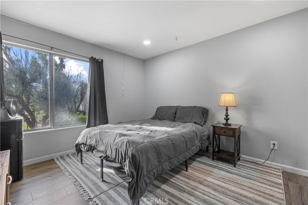 23515 Lyons Avenue, Unit 277 Valencia, CA 91355 - Photo 10 of 29 a bedroom with a bed and wooden floor