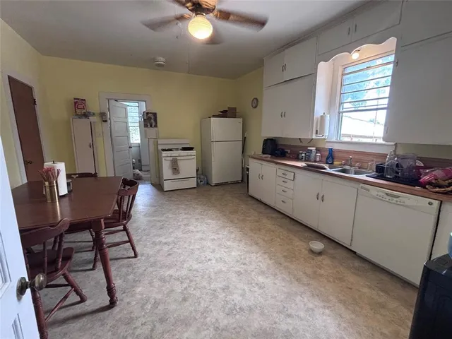 a kitchen with a sink chairs and cabinets