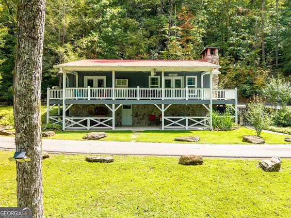 a view of a house with a backyard patio and swimming pool