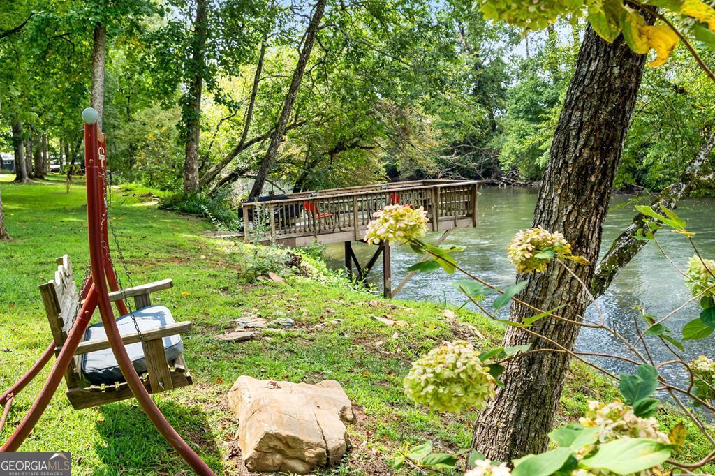 270 Hiawassee River Road Murphy, NC 28906 - Photo 40 of 50 a backyard of a house with table and chairs potted plants and large tree