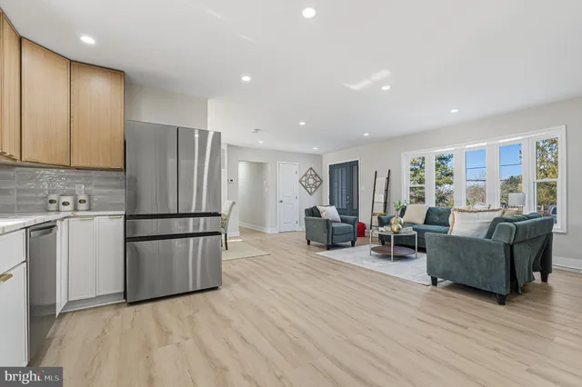 a living room with furniture and a refrigerator