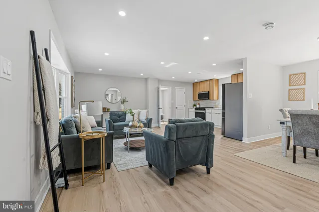 a living room with furniture a large window and wooden floor