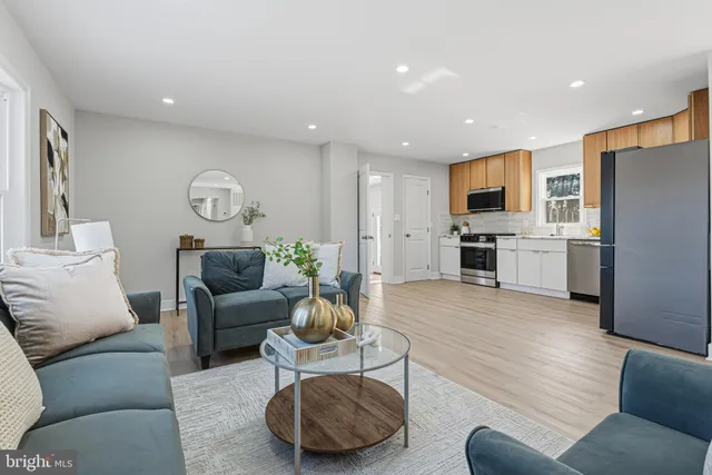 a living room with furniture and a refrigerator