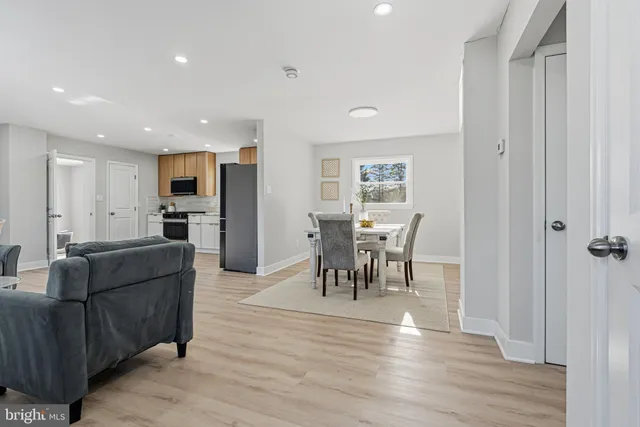 a living room with furniture and a dining table with kitchen view