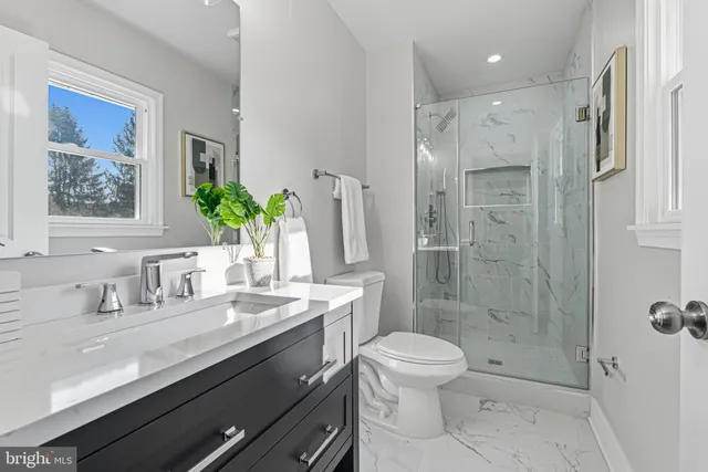 a bathroom with a shower a toilet and a sink