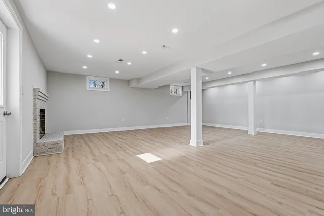 a view of empty room with wooden floor and fireplace