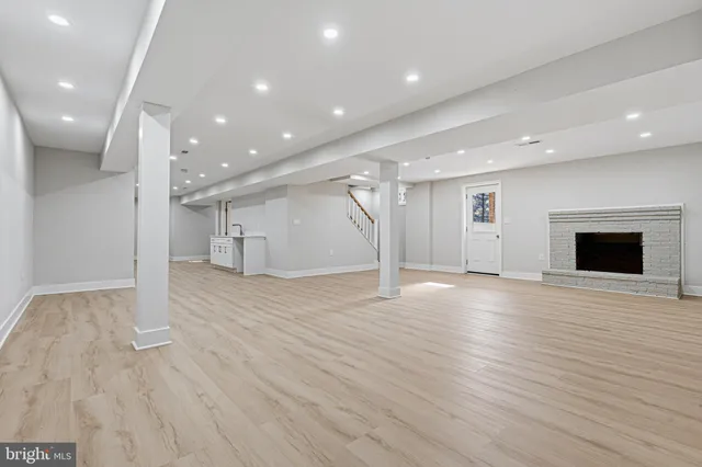a view of empty room with wooden floor and fireplace
