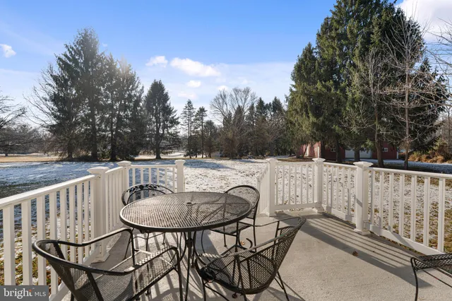 a patio with table and chairs and potted plants