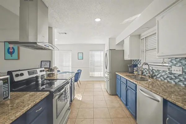 a kitchen with granite countertop a sink stove and cabinets