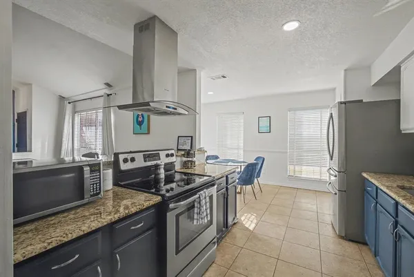 a kitchen with granite countertop a sink a counter top space stainless steel appliances and cabinets