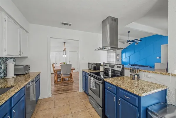 a kitchen with granite countertop a sink stove and cabinets