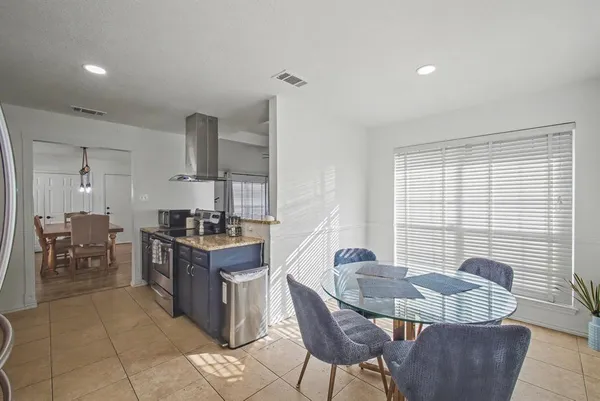 a kitchen with stainless steel appliances granite countertop a stove a sink a table and chairs