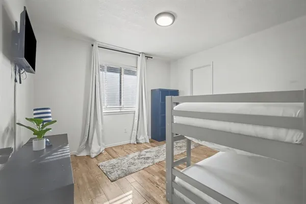 a living room with a bed furniture and a flat screen tv