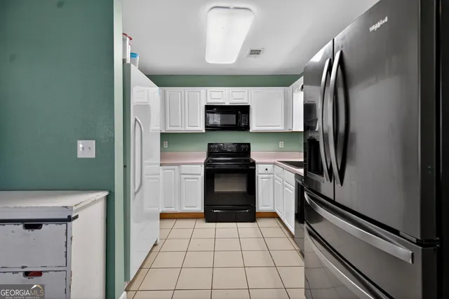 a kitchen with a refrigerator a stove and a sink